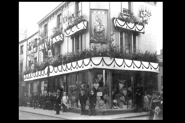 Exterior of E. Francis & Sons Ltd. shop, Bath Street, Leamington, with employees standing in front. The shop is decorated with flags and bunting, possibly to celebrate the coronation of King George V. Photo from the Our Warwickshire website.