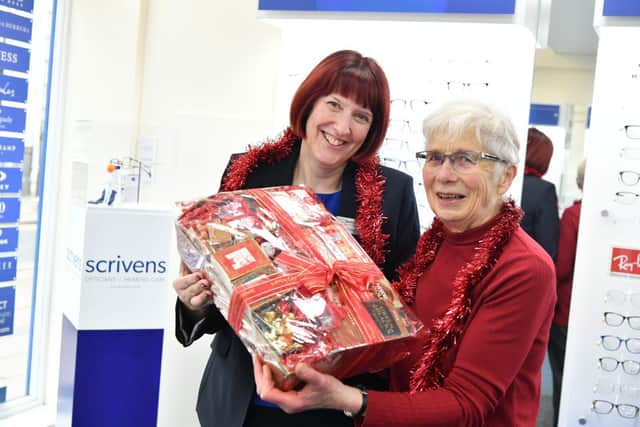 Scrivens Rugby branch manager, Sarah Cave, presenting customer Jane Muers with a festive surprise