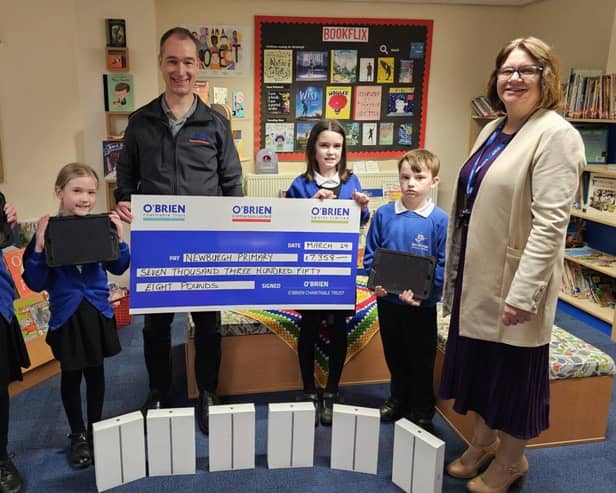 Newburgh Primary School pupils proudly accepting a donation from the O'Brien Charitable Trust