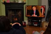 Members of a family listen as Britain's Prime Minister Boris Johnson makes a televised address to the nation from inside 10 Downing Street with the latest instructions to stay at home to help contain the Covid-19 pandemic (Photo: PAUL ELLIS/AFP via Getty Images)