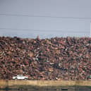 A vehicle passes a towering pile of scrap metal at Southampton port.