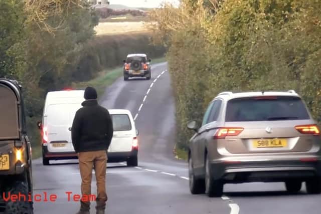 Traffic tries to pass the scene where vehicles have stopped for the hunt which WMHS says chased three foxes onto the B4035