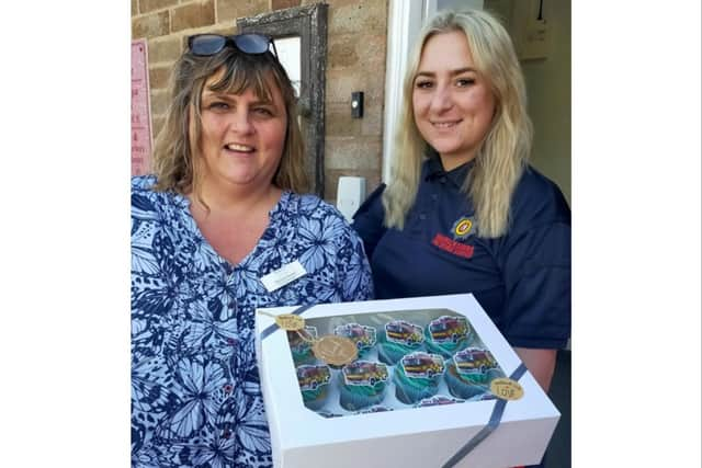 One of the team members from Leycester House handing out cupcakes to one of the emergency workers at Leamington fire station. Photo supplied