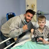 Leamington Boxer Danny Quartermaine meets a young patient at Warwick Hospital's MacGregor Children's Ward. Image courtesy of Reece Singh Promotions.