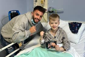 Leamington Boxer Danny Quartermaine meets a young patient at Warwick Hospital's MacGregor Children's Ward. Image courtesy of Reece Singh Promotions.