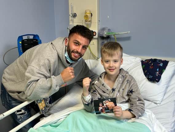 Leamington Boxer Danny Quartermaine meets a young patient at Warwick Hospital's MacGregor Children's Ward. Image courtesy of Reece Singh Promotions.