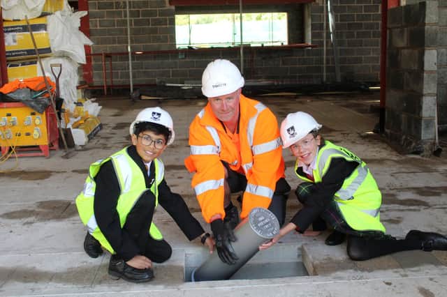 Burying The Time Capsule left to right Year 7 Krishan Patel, Trendrey Site Manager Kevin Wynne, and Year 7 Lauren Dent. Photo supplied