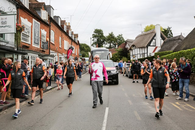 Batonbearer Iain Wilson holds the Queen's Baton during the Birmingham 2022 Queen's Baton Relay on a visit to Kenilworth on July 22, 2022