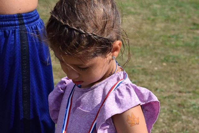 A young girl admires her medal.
