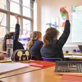 File photo dated 12/09/18 of a teacher and students in a classroom, as the Government's plan for all state schools to deliver at least a 32.5 hour week has been pushed back by a year.