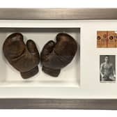 Warwick boxing legend Randolph Turpin's gloves, which he wore during his preparation for his fight against Sugar Ray Robinson which he won to become the Middleweight Champion of the World. They are framed with a programme cover and ticket from the fight, which took place ay Earls Court in London on July 10, 1951.