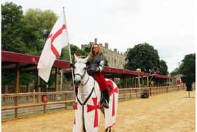 One of the women stunt riders from The Knights of Middle England flies St George's Flag at Warwick Castle's jousting arena. Credit Warwick Castle.