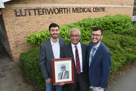 Ravi, Vipu and brother Ajay, a junior doctor, with a photograph of grandfather Bhogilal. Photo: Andrew Carpenter