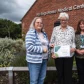Eileen Edwards, a trustee of the Friends of Hastings House, receives a cheque from Cllr Anne Prior of Wellesbourne Parish Council, which will primarily help to fund the work of Wendy Walters, pictured right.