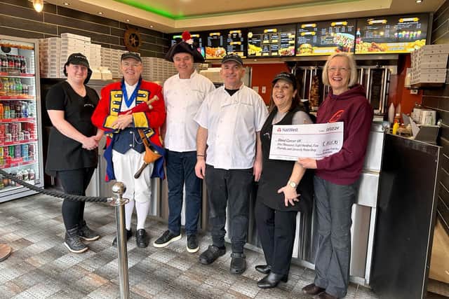 Anne Oliver receives the cheque from Michael Michaels, watched by Warwick Town Crier, Michael Reddy.