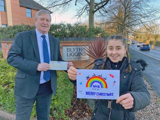 Ellie Wall, Last year's winner of our Christmas card competitio,n receives her £100 prize from Blythe Liggins senior partner David Lester.