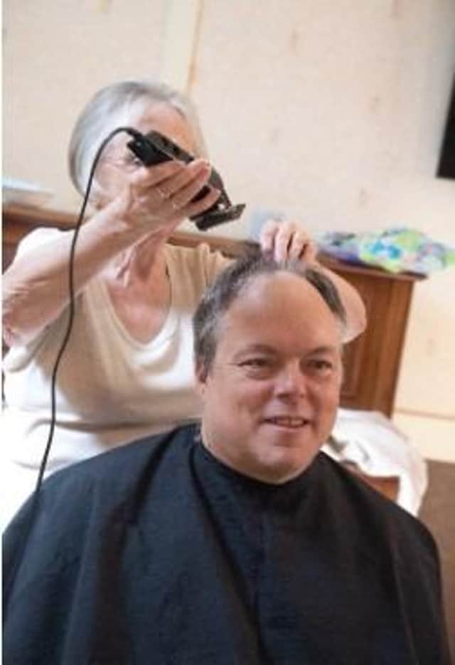 Pauline Kimber shaves David Fleming's hair.