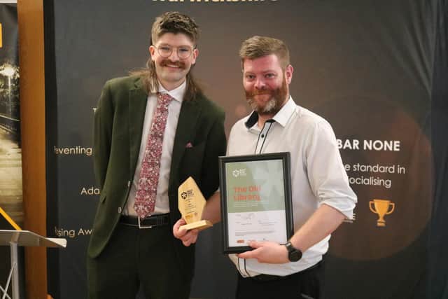 Best Bar None representative Isaac Alcántara Heatlie presenting a representative from the The Old Library in Leamington with the Best Student Friendly Venue award. Photo by Warwickshire County Council