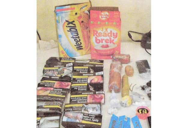 Cereal boxes and the goods that were seized when being smuggled into HMP Hewell. Release date – November 16, 2023.  See SWNS story SWMRprison.  A prison officer who was the ringleader of a smuggling gang supplying inmates with drugs and mobile phones hidden inside boxes of CEREAL has been jailed.   Martin Mills, 34, was caught red-handed trying to smuggle prohibited items into HMP Hewell concealed in packs of Weetabix and Ready Brek.  A court heard he was stopped as he arrived for work at the category B jail near Redditch, Worcs., after his bosses became suspicious in April 2018. Detectives were able to link several other people to the smuggling ring, including prisoners housed on the block Mills worked on. Family members of the lags would pay money into Mills’ bank account and he would then take the prohibited items to work for the prisoners to sell on inside.  Photos show how drugs, phones, SIM cards, tobacco, Rizlas, wads of cash and even a knife were recovered as part of the operation. Mills, of Bromsgrove, Worcs., pleaded guilty to smuggling list A items (drugs) and list B items (mobile phones and associated equipment).  He was jailed for four years at Worcester Crown Court on Monday (13/11).  Mills was sentenced alongside eight other people for conspiracy to bring, throw and convey prohibited items in to the prison. 
