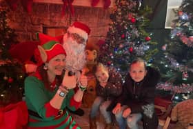 Swim manager, Steph, dressed as an elf with Santa and visiting children.