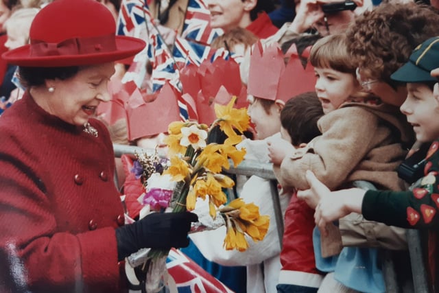 The Queen stops to talk to members of the public outside the Royal Priors shopping centre.