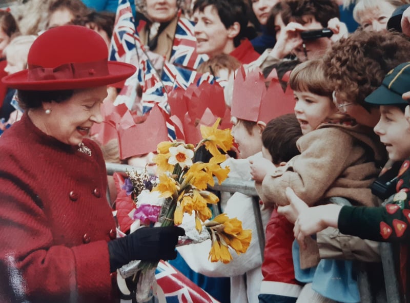 The Queen stops to talk to members of the public outside the Royal Priors shopping centre.