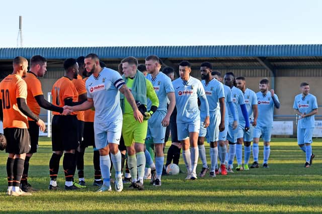 Rugby Town, led by captain Loyiso Recci, shake hands with local rivals Lutterworth Town before they went on to claim a fine 5-2 win over them in the Boxing Day derby at Butlin Road. Pictures by Martin Pulley