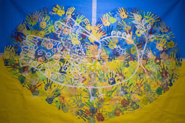 The giant Ukrainian flag created by refugees in Rugby, featuring the painted handprints of all the refugee children in the town.