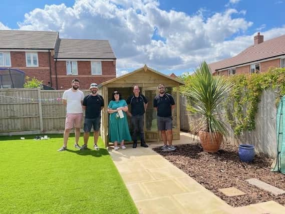The JLR team handing over the summerhouse retreat. Photo supplied
