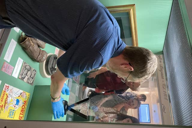 Curator Huw Jones places the award in the display case at Leamington Art Gallery & Mueum while Turpin family members look on. Picture submitted.