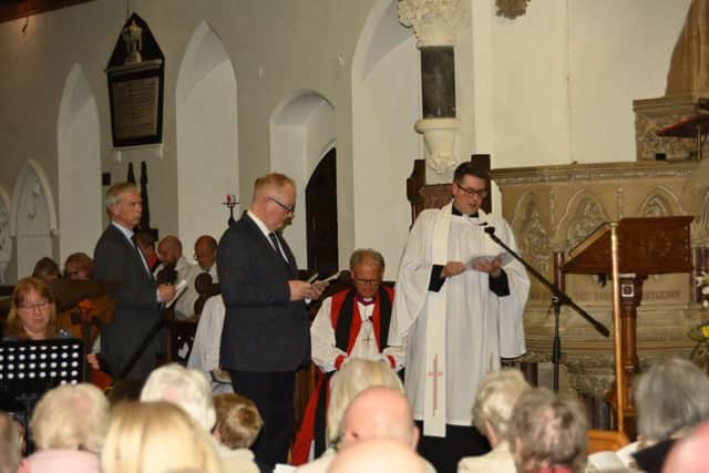 Rev Ben Cook at the service with Bishop of Coventry seated behind and churchwardens Adrian Barton and Simon Greaves standing.