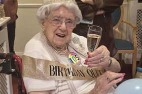 Cheers! Marjorie raises a glass with friends and family to mark her 105th birthday.