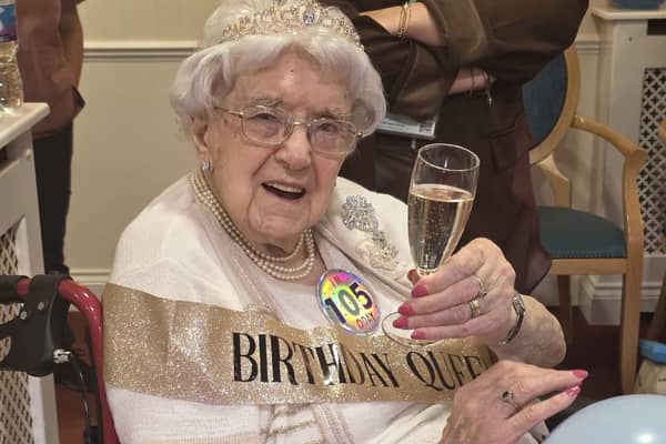 Cheers! Marjorie raises a glass with friends and family to mark her 105th birthday.