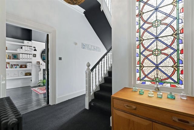 The entrance hall features a stained glass window. Photo by Fine and Country