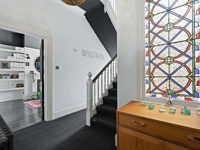The entrance hall features a stained glass window. Photo by Fine and Country