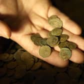 Part of a Roman coin hoard found in Snodland in north Kent is looked at closely by a British Museum worker; the coin hoard, discovered by a digger driver, is made up of over 3,600 coins and is part of the British Museum's annual report of treasure finds at the British Museum in London.