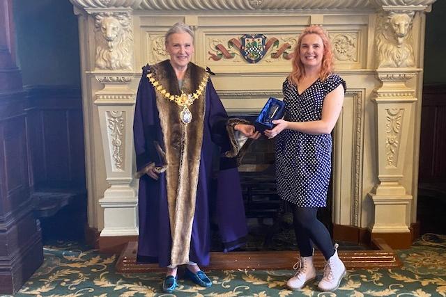 Charlie Demetriou receives her award from Leamington Mayor Cllr Susan Rasmussen 'for championing zero waste in the town'.
Cllr Rasmussen said: "Charlie started a zero waste business just before lockdown. 
"Initially she had a stall in the Covent Garden Street Market before taking premises just round the corner. 
"She sells loose groceries, so that there is no packaging and no waste; she sells eco-friendly cleaning and washing products - you just take your old containers and fill them. "She sells confectionary and toiletries. 
"She and her staff are unfailingly charming, hardworking and dedicated to the principles of zero waste. 
"During lockdown she adapted admirably and became an important part of the lives of all her customers. 
"Zero is a shining star in Leamington’s retail sky."
(Picture submitted).