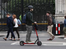 A person riding an electric scooter in Westminster, London.