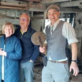 Visitors with volunteer guides Margaret Taylor (left) who is holding a name board from a Victorian waggon, and Derek Apps (right) with a ‘traveller’ that measured cartwheel hoops. Photo by Janet Hall