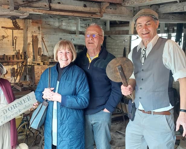 Visitors with volunteer guides Margaret Taylor (left) who is holding a name board from a Victorian waggon, and Derek Apps (right) with a ‘traveller’ that measured cartwheel hoops. Photo by Janet Hall
