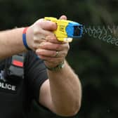 File photo 26/02/13 of a police officer demonstrating the use of a Taser as a majority of the public think it is acceptable for police to carry Tasers when on patrol, a survey suggests.