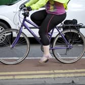 File photo dated 07/08/13 of a person cycling next to a car, as government targets to increase levels of cycling and walking in England are set to be missed, according to a new report.
