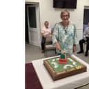 Gail Hart, one of the founding members of Kenilworth Bridge Club, cuts the cake to celebrate the club's 50th anniversary.