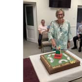 Gail Hart, one of the founding members of Kenilworth Bridge Club, cuts the cake to celebrate the club's 50th anniversary.