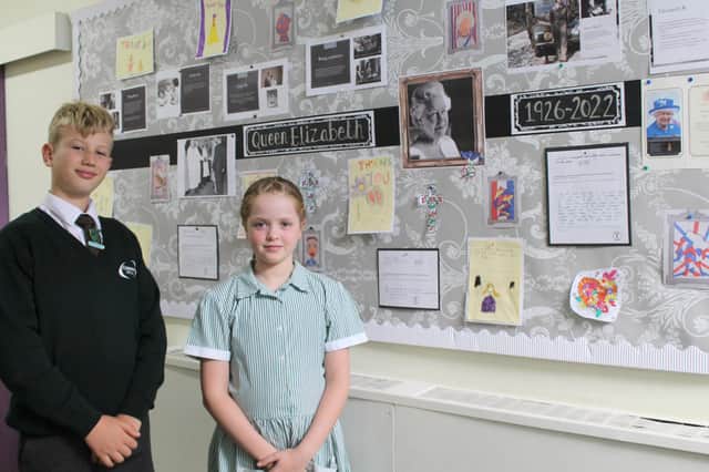 Head boy and head girl, Charlie Millward and Esme Barlow, in front of the display board created in the school to mark the Queen’s passing.