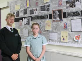 Head boy and head girl, Charlie Millward and Esme Barlow, in front of the display board created in the school to mark the Queen’s passing.