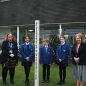 Campion School pupils place the Peace Pole outside the school's entrance with Julie Gardner, Head of RE (left), and Margaret Morley, Rotarian (right). Picture supplied.