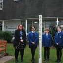 Campion School pupils place the Peace Pole outside the school's entrance with Julie Gardner, Head of RE (left), and Margaret Morley, Rotarian (right). Picture supplied.