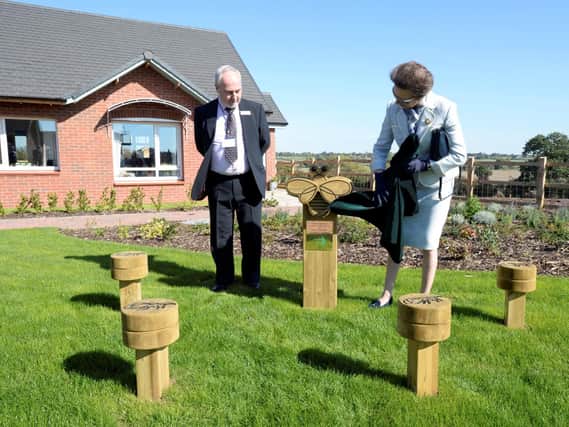 HRH The Princess Royal  revealing the wooden bee sculpture to honour Denis Keyte. Photo supplied.