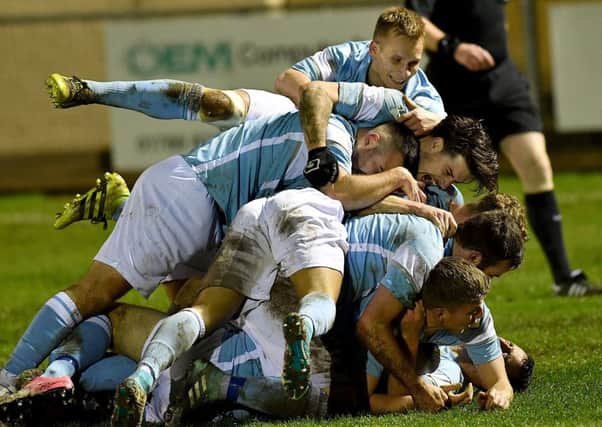 Sam Lockley is mobbed after scoring the winner  PICTURES BY MARTIN PULLEY